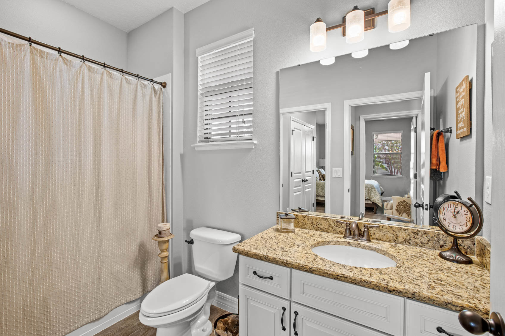 bathroom with white cabinet and brown counter